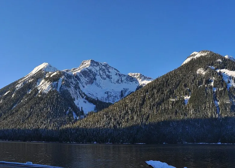 Chilliwack Lake on a clear winter day, snow on the peaks above calm water