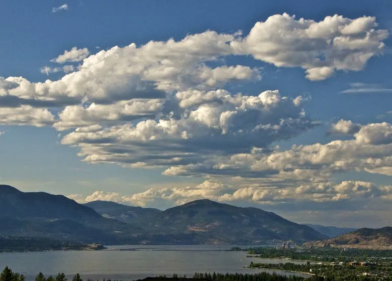 Okanagan Lake at Kelowna under a sky full of cumulus clouds, the bridge across the lake below